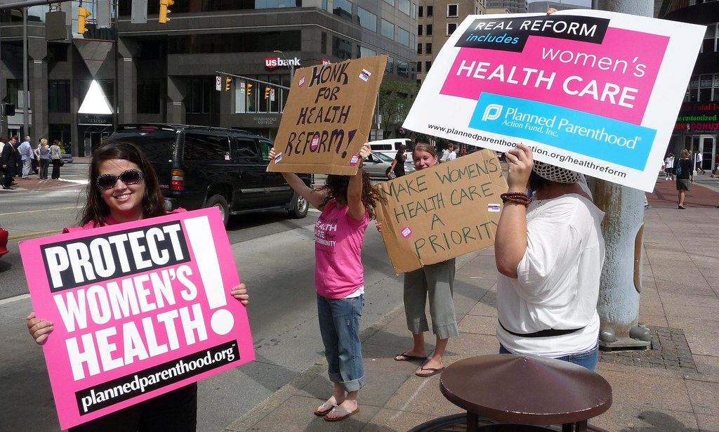 women raising signs for protection of women's health rights