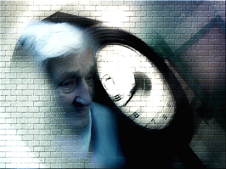 A brick wall with a blurred photo of a face of an elderly woman by a clock