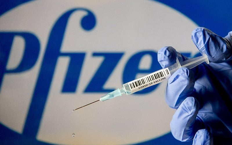 a covid vaccine with a pfizer logo in the background